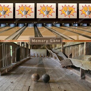 以下が含まれることがあります： 木製のレーンと素朴な木造の構造を持つビンテージボウリング場。レーンには「Memory Lane」と書かれた看板があります。床にはボウリングボールが2つあります。