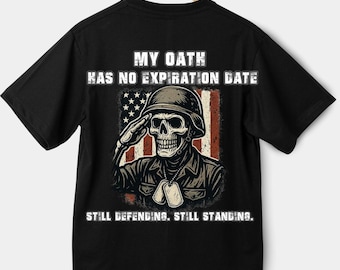 Puede incluir: Camiseta negra con un gráfico de una calavera saludando con un casco militar, con una bandera estadounidense de fondo. El texto dice "MY OATH HAS NO EXPIRATION DATE" y "STILL DEFENDING. STILL STANDING."