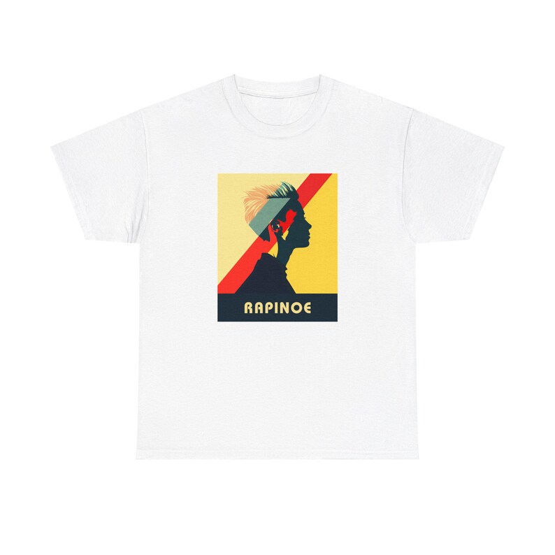 May include: White t-shirt with a graphic of a person's silhouette with a red and yellow background. The text "RAPINOE" is printed below the graphic.
