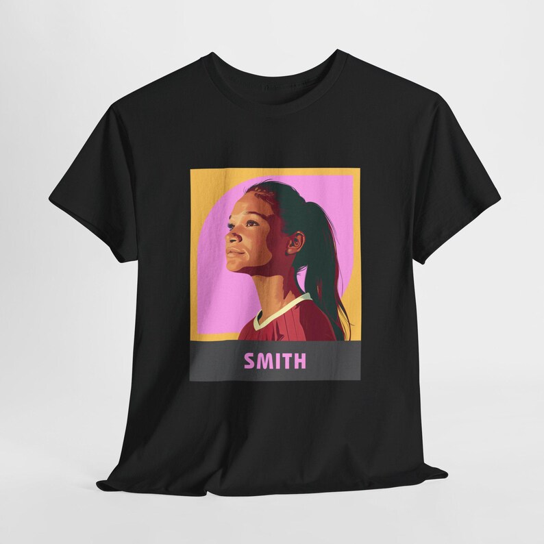 May include: Black t-shirt with a graphic of a young woman with a pink and yellow background. The text "SMITH" is printed below the graphic.
