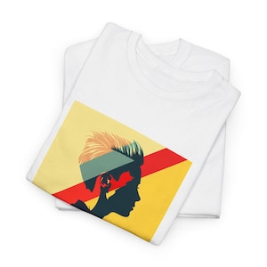 May include: White t-shirt with a graphic of a person's head with a yellow, red, and green design.