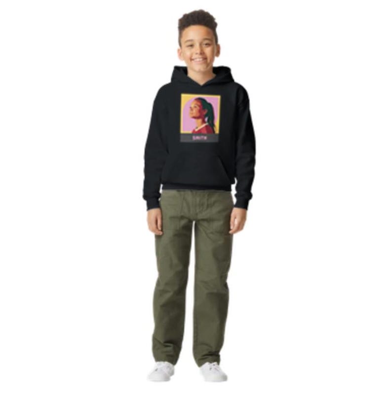 Puede incluir: Sudadera con capucha negra con un gr&aacute;fico de la cara de una mujer en la parte delantera. El gr&aacute;fico est&aacute; en un esquema de color amarillo, rosa y rojo. El texto "SZA" est&aacute; debajo del gr&aacute;fico.