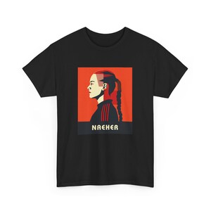May include: Black t-shirt featuring a red and white graphic of a woman with a braid and the word "NAEHER" in yellow.