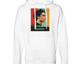 May include: White hoodie with a retro-style graphic of a soccer player with the name "OCHOA" printed below.