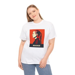 May include: White t-shirt featuring a red and blue graphic of a woman with the word "NACHER" printed below.