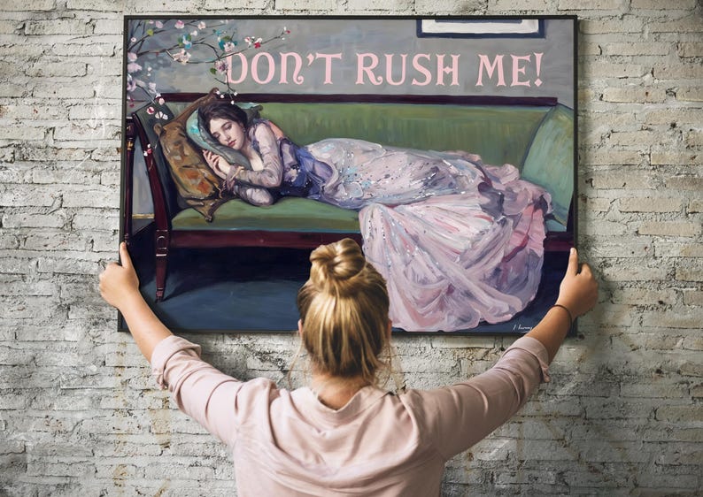 May include: A framed painting of a woman in a pink dress lying on a green couch. The painting has the text "DON'T RUSH ME!" in pink letters at the top.