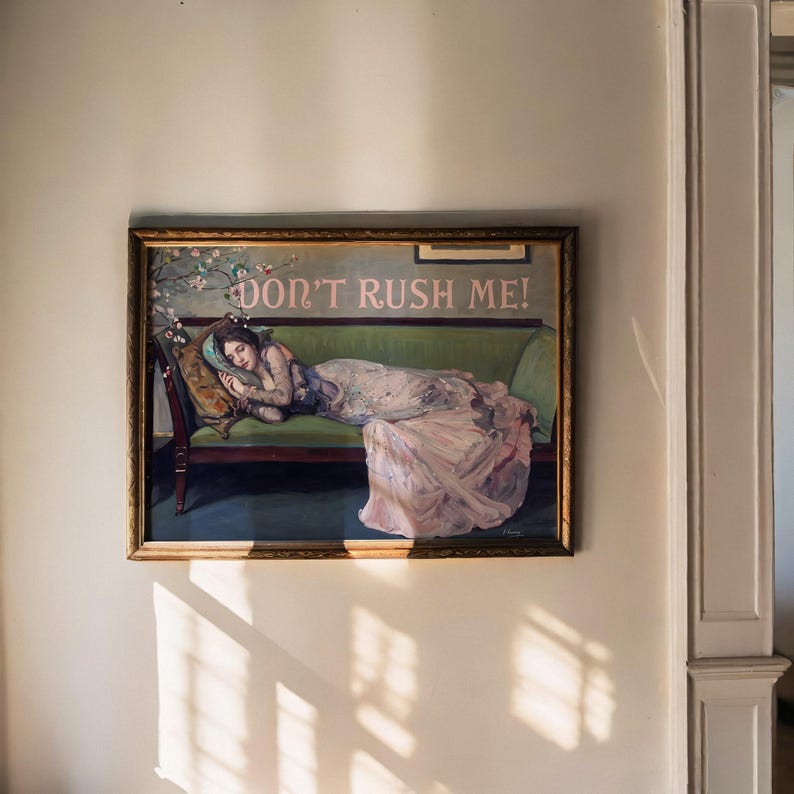 May include: A framed painting of a woman lying on a green couch. The woman is wearing a white dress and has her head resting on a pillow. The painting is titled "Don't Rush Me!"