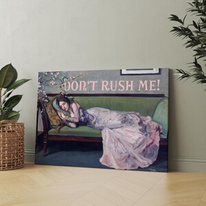 May include: A painting of a woman in a pink dress lying on a green couch. The woman is asleep and the couch is decorated with pink flowers. The text "DON'T RUSH ME!" is written in pink letters above the couch.