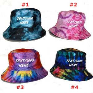 May include: Four tie-dye bucket hats in different color combinations. Each hat features the text "TEXT/LOGO HERE" in white lettering.