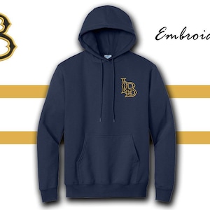 Może przedstawiać: Granatowa bluza z kapturem z przednią kieszenią i sznurkiem. Bluza posiada haftowane, złote logo "LB" na piersi oraz większą wersję w lewym górnym rogu. Słowo "Haft" jest napisane kursywą.