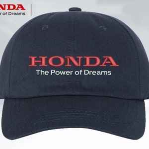 Puede incluir: Una gorra de béisbol azul marino con un logotipo de Honda bordado en rojo y el texto "The Power of Dreams".