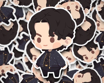 May include: A sticker featuring a cartoon illustration of a person with black hair and a black and gold jacket. The person is wearing a black shirt and black pants. The sticker has a white outline.