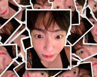 May include: A collection of stickers featuring a person with dark hair, a lip piercing, and a black tank top. The stickers have a white border and are arranged in a scattered pattern, with the person's face visible in each sticker.