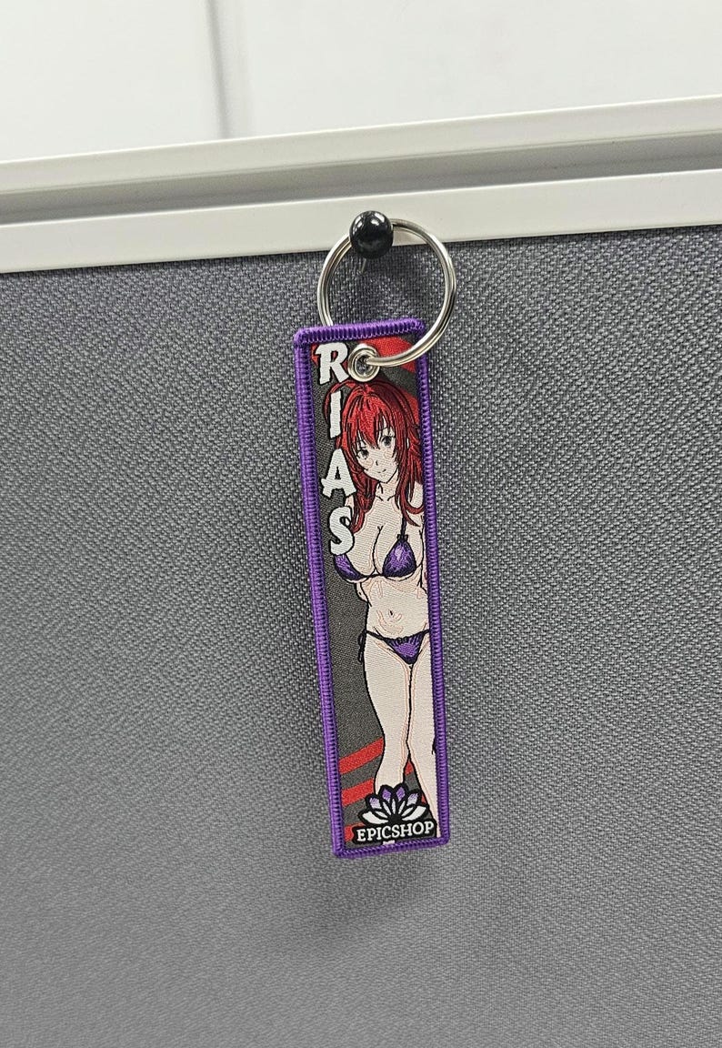 May include: Purple keychain with a cartoon anime woman wearing a bikini and the text "RIAS" and "EPICSHOP".