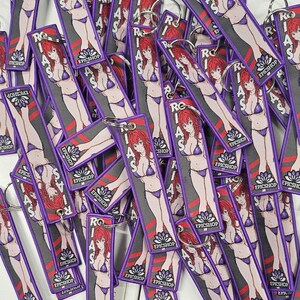 May include: A pile of purple keychains with a cartoon image of a woman in a bikini. The keychains have the text "RIAS" and "EPICSHOP" printed on them.