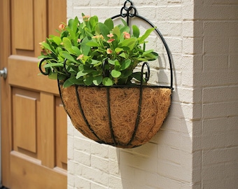 Cesto portavaso sospeso in fibra di cocco fatto a mano, con struttura in ferro rustico, ideale per decorare balconi e giardini.