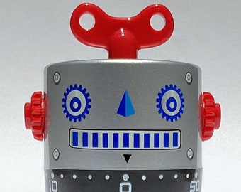 May include: A silver robot-shaped kitchen timer with a red wind-up key on top. The timer has a blue and white face with a blue triangle and two blue gears. The timer has a black dial with numbers from 10 to 50.