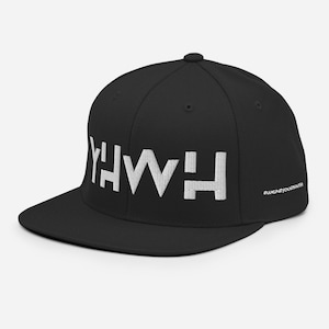May include: Black and white flat brimmed baseball cap with the word "Y'HWH" embroidered in white on the front. The hashtag "#wearsyourfaith" is printed in white on the back of the cap.