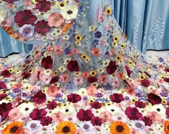 May include: A sheer fabric with embroidered floral designs in shades of pink, yellow, red, and blue. The flowers are 3D and have a delicate, feminine look.