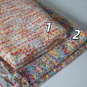 May include: Two pieces of textured fabric with a multicolored speckled pattern. Piece 1 features a blend of red, orange, and light blue flecks on a white base. Piece 2 displays a denser mix of blue, yellow, pink, and green flecks on a white base.