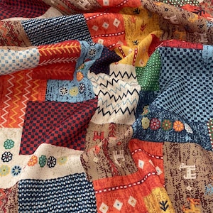 May include: A patchwork fabric with a variety of patterns and colors. The design includes squares and rectangles in shades of red, blue, yellow, and brown. The fabric has a textured appearance with floral and geometric motifs.