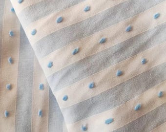 May include: A light blue and white striped fabric featuring a textured swiss dot pattern. The material displays alternating vertical stripes of solid light blue and white, with small, raised light blue tufted dots evenly spaced across the white sections.