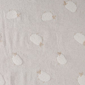 Puede incluir: Una tela beige con un patr&oacute;n repetido de ovejas bordadas blancas. Las ovejas son estilizadas y tienen un dise&ntilde;o simple.