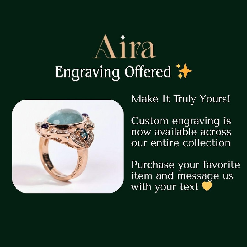 K&ouml;nnte beinhalten: Ein ros&eacute;goldener Ring mit einem gro&szlig;en, hellblauen Edelstein und kleineren lila und blauen Steinen. Der Ring hat ein detailliertes Design und ist vor einem dunkelgr&uuml;nen Hintergrund platziert. Der Text auf dem Bild lautet "Aira Gravur angeboten."