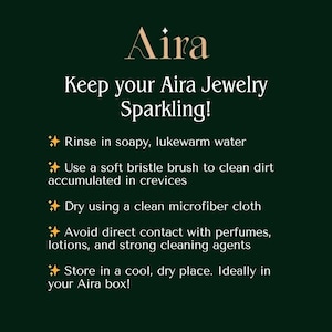 K&ouml;nnte beinhalten: Dunkelgr&uuml;ne Grafik mit dem goldenen Text "Aira" oben. Darunter steht "Keep your Aira Jewelry Sparkling!" gefolgt von Reinigungsanweisungen. Die Anweisungen umfassen Sp&uuml;len, B&uuml;rsten, Trocknen, Vermeiden von Kontakt und Aufbewahren von Schmuck.