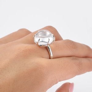 Puede incluir: Un anillo de plata con una piedra de cuarzo transparente engastada en garras.