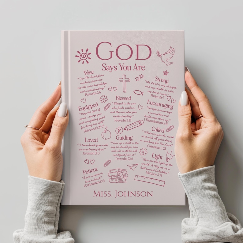 May include: A hardcover journal with the words "GOD Says You Are" in a decorative font. The cover features inspirational words and phrases, including "Wise," "Loved," and "Blessed," along with a name at the bottom.