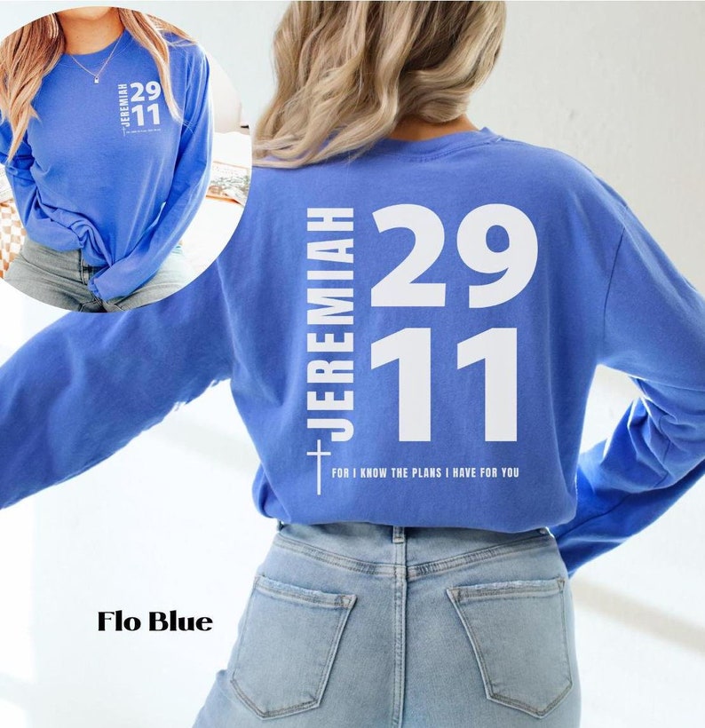 Op de afbeelding: Een langarm, lichtblauw T-shirt met witte tekst op de rug. De tekst luidt "Jeremia 29:11" en "Want ik weet welke plannen ik voor jullie heb".
