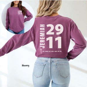 Op de afbeelding: Een langarm, maroon t-shirt met een wit kruis, de tekst "JEREMIAH 29:11" en de woorden "FOR I KNOW THE PLANS I HAVE FOR YOU".