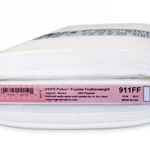 Peut inclure: Rouleau de tissu blanc Pellon 911FF Fusible Featherweight. L'&eacute;tiquette indique "Apparel-Basics" et "100% Polyester". Le rouleau mesure 50.8 cm de large et est fabriqu&eacute; aux &Eacute;tats-Unis.