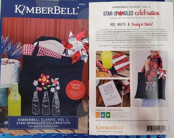 Peut inclure: Un kit de broderie machine Kimberbell Classic Vol. 1 Star-Spangled Celebration. La couverture présente un sac fourre-tout bleu marine avec des motifs floraux et de bouteilles patriotiques, et un thème rouge, blanc et bleu. Inclut des fichiers numériques.