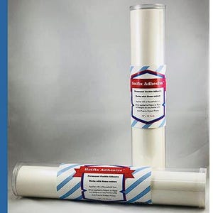 May include: Two rolls of white adhesive material in clear plastic tubes. Each roll has a label that reads "Hotfix Adhesive" with blue and red accents. The rolls are 12 inches by 12 yards.