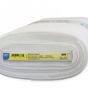 Peut inclure: Un rouleau de tissu blanc avec l'&eacute;tiquette "809 D&eacute;cor-Bond". L'&eacute;tiquette jaune indique que le tissu mesure 114 cm de large et est compos&eacute; &agrave; 100 % de polyester. Le tissu est destin&eacute; aux travaux manuels et &agrave; la d&eacute;coration int&eacute;rieure.