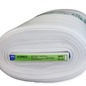 Peut inclure: Un grand rouleau de tissu polaire fusible Pellon blanc. L'&eacute;tiquette indique le nom du produit, 987F, et d'autres d&eacute;tails. Le tissu mesure 114 cm de large et est fabriqu&eacute; aux &Eacute;tats-Unis. La polaire est 100% polyester et convient au quilting et autres projets de couture.