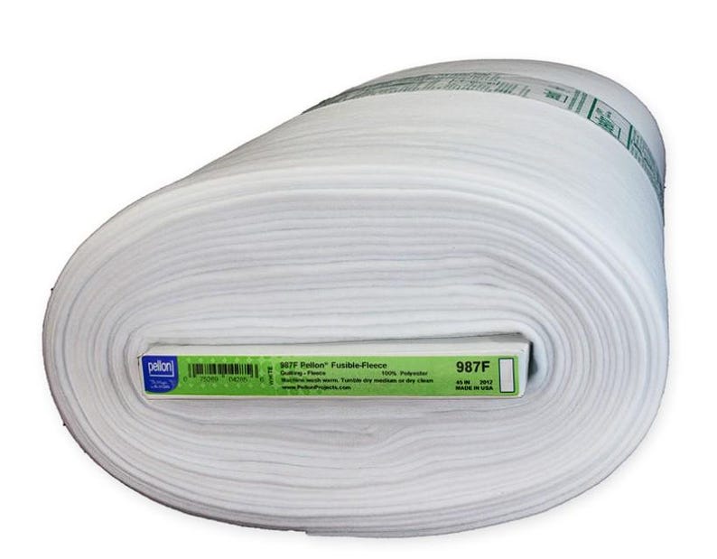 Peut inclure: Un grand rouleau de tissu polaire fusible Pellon blanc. L'&eacute;tiquette indique le nom du produit, 987F, et d'autres d&eacute;tails. Le tissu mesure 114 cm de large et est fabriqu&eacute; aux &Eacute;tats-Unis. La polaire est 100% polyester et convient au quilting et autres projets de couture.