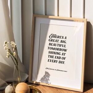 May include: A framed print with a white background and black text that reads "There's a great. big. beautiful tomorrow shining at the end of every day. The Carousel of Progress (1967)"