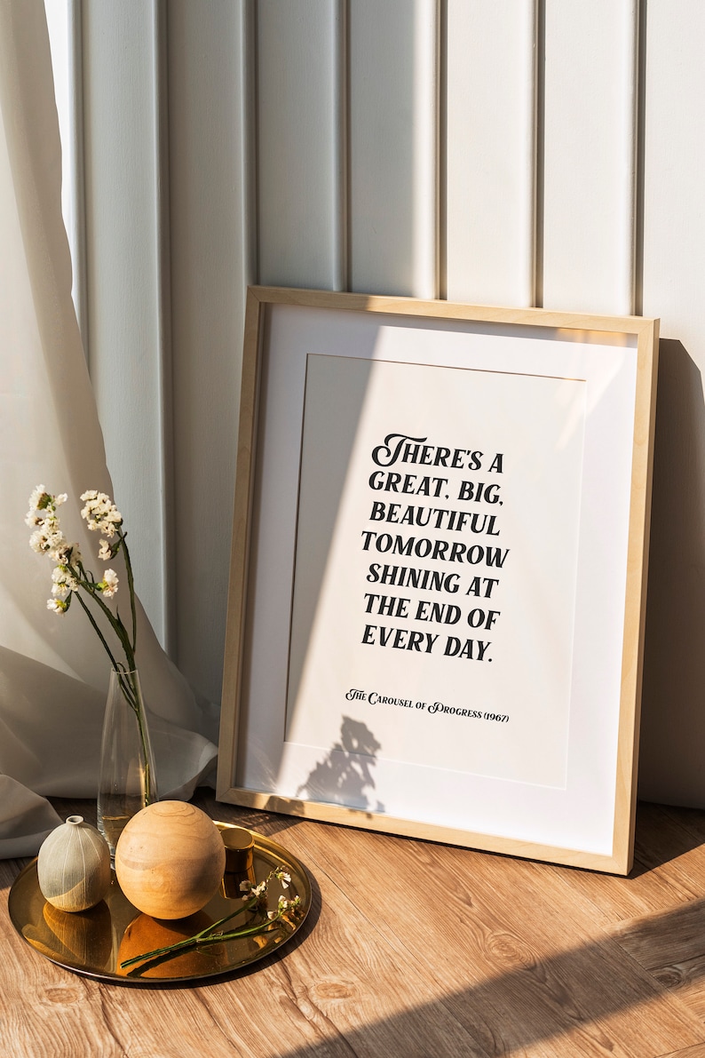 May include: A framed print with a white background and black text that reads "There's a great. big. beautiful tomorrow shining at the end of every day. The Carousel of Progress (1967)"