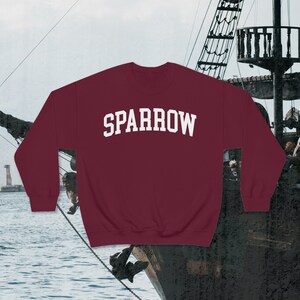 Op de afbeelding: Een bordeauxrood sweatshirt met het woord "SPARROW" in wit op de voorkant.
