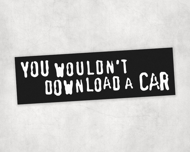 Peut inclure: Panneau rectangulaire noir avec le texte blanc "YOU WOULDN'T DOWNLOAD A CAR". Le texte est en gras, en police sans empattement. Le panneau est pos&eacute; sur un fond gris clair.