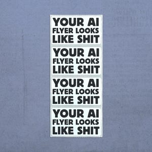 May include: A vertical sheet of four rectangular stickers, each featuring the black text "YOUR AI FLYER LOOKS LIKE SHIT" printed in a bold, sans-serif font on a white background. The stickers are arranged in a single column, one above the other.