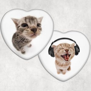 Puede incluir: Dos imágenes en forma de corazón con gatitos. Una muestra un gatito atigrado gris. La otra muestra un gatito marrón claro con auriculares negros y parece estar riendo con la boca abierta. El fondo es de color blanco roto texturizado.