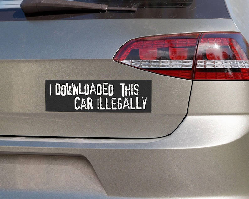Peut inclure: Un autocollant de pare-chocs rectangulaire noir avec le texte blanc "I DOWNLOADED THIS CAR ILLEGALLY" est appos&eacute; &agrave; l'arri&egrave;re d'une voiture argent&eacute;e. Le feu arri&egrave;re rouge de la voiture est visible.