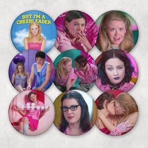 May include: A collection of nine round pinback buttons featuring images of characters from the movie "But I'm a Cheerleader." The buttons display various scenes and portraits, with a blue button featuring the text "But I'm a Cheerleader."