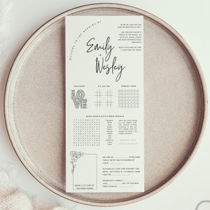 K&ouml;nnte beinhalten: Eine druckbare Hochzeitsempfangsspielkarte mit einem schwarz-wei&szlig;en Design. Die Karte enth&auml;lt ein Wortsuchspiel, Vier gewinnt, Tic Tac Toe und ein Liebeslabyrinth. Die Karte enth&auml;lt auch die Namen Emily und Wesley sowie den Text "Willkommen zur Hochzeit von".