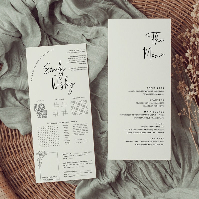 May include: A wedding menu card with a black and white design. The menu includes starters, main course, sides, and desserts. The text "The Menu" is written in a cursive font at the top of the card.