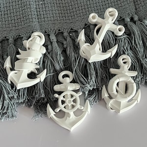 May include: Four white ceramic anchors of different styles. The anchors are arranged on a gray textured surface.